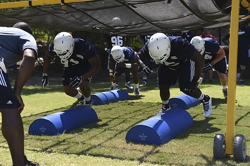 Defensive linemen Josh Freeman, left, and Keionta Davis run a drill during the first day of football practice for the University of Tennessee at Chattanooga on Aug. 3. Freeman said he won't miss the more frequent two-a-day practice schedules that are no longer possible under NCAA rules.