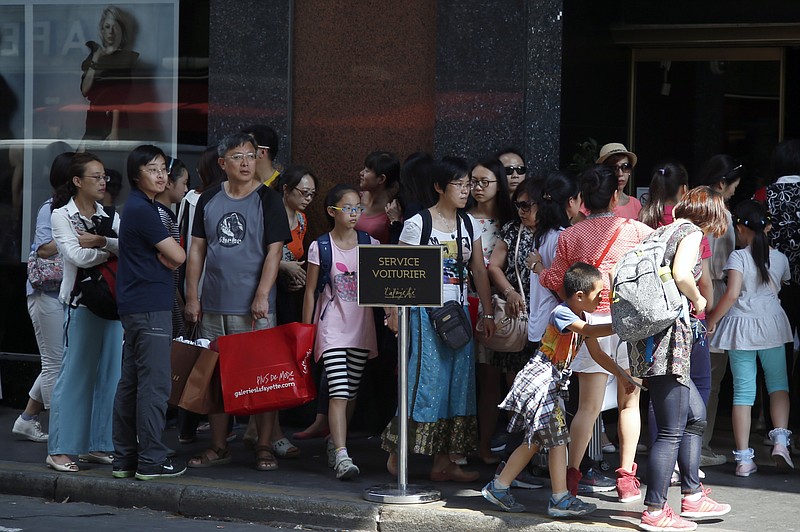 
              Chinese tourists queue to enter in a fashion store in Paris,  Wednesday, Aug. 12, 2015. China's currency fell further Wednesday following a surprise change in its exchange rate mechanism that rattled global markets and threatens to fan trade tensions with the United States and Europe. The central bank said the yuan's 1.9 percent devaluation Tuesday against the U.S. dollar, which was its biggest one-day fall in a decade, was due to changes aimed at making the tightly controlled currency more market-oriented. (AP Photo/Francois Mori)
            