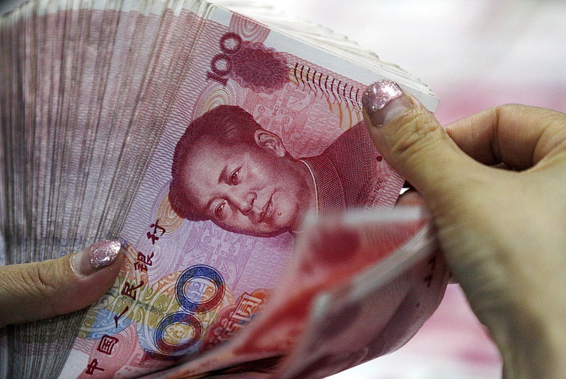
              In this Tuesday, Aug. 11, 2015 photo, a bank clerk counts Chinese currency notes at a bank outlet in Huaibei in central China's Anhui province. China’s surprise move on Tuesday to devalue its currency has intensified concerns about a slowdown in the world’s second-largest economy, whose growth rate has reached a six-year low. It is also fanning tensions with the United States and Europe, whose exports could become comparatively costlier. (Chinatopix via AP) CHINA OUT
            