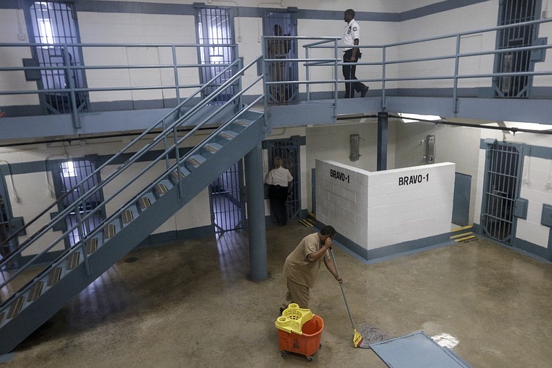 An inmate mops the floor in the Bravo Unit men's ward on Tuesday, June 30, 2015, at Silverdale Correctional Facility in Chattanooga, Tenn.