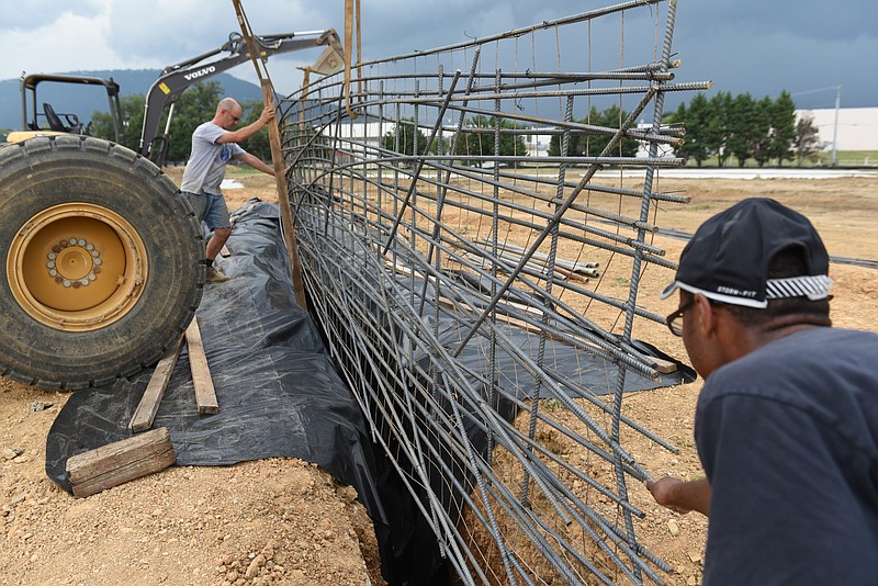 Sculptor Peter Lundberg, assisted by Desmond Lewis, right, works at the sculpture field at Montague Park on his memorial to the service members slain in Chattanooga on July 16.