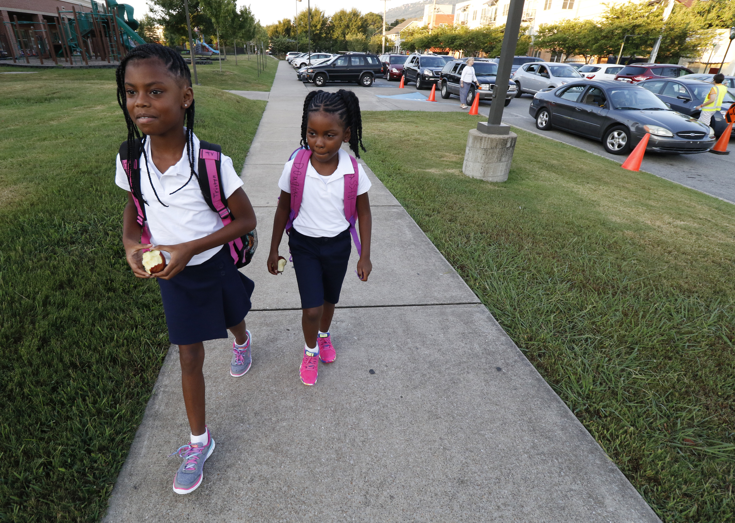 Fourth grade student Tristyn Vaughn walks her sister Kassidy Douglas to the first grade hall during the first day of school on Thursday, August 13, 2015 at Battle Academy.