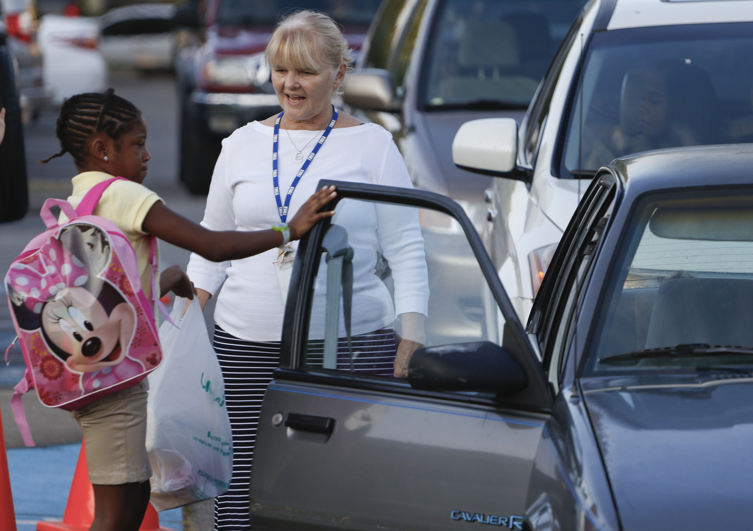 Elizabeth Bracken greets fourth grade student Africa Freeman as she is dropped off during the first day of school on Thursday, August 13, 2015 at Battle Academy.