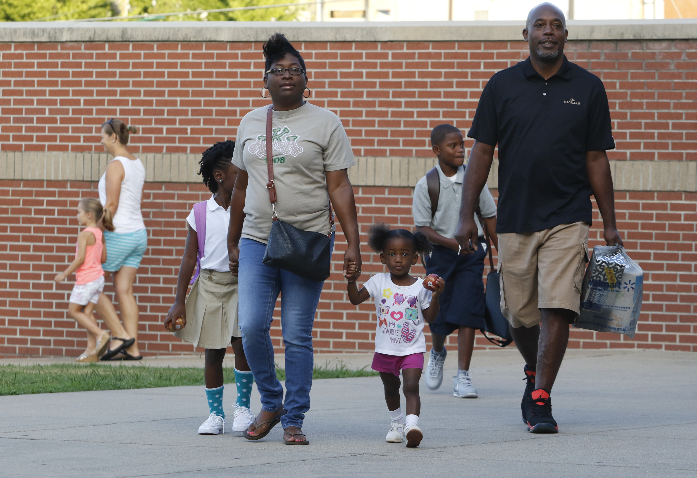 Alexandria Harden, Avery Harden, LaTasha Harden and Roddaze Harden make their way onto campus during the first day of school on Thursday, August 13, 2015 at Battle Academy.