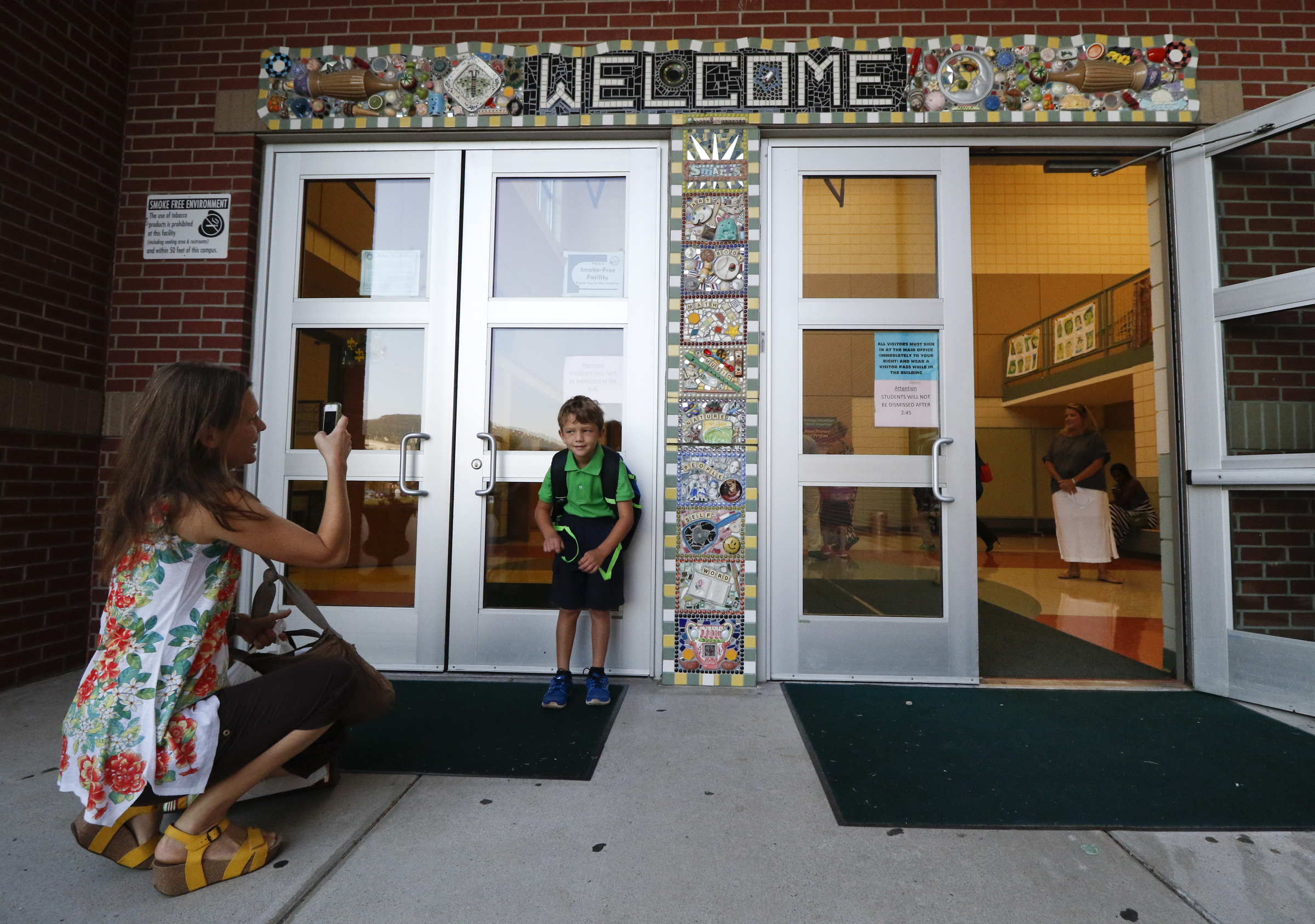 Katie Davis takes a photo of her second grader son Josiah Davis during the first day of school on Thursday, August 13, 2015 at Battle Academy.