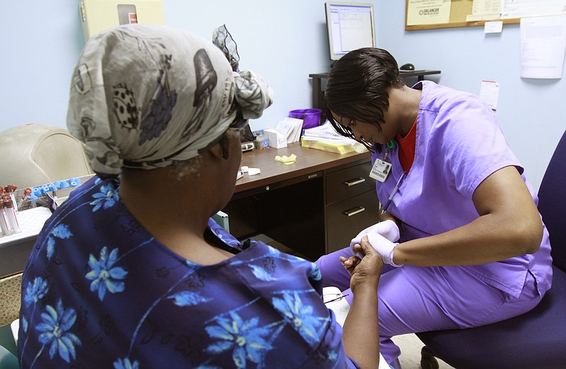 A patient has her blood sugar checked at the Southside Community Health Center by a specimen procurement technician.