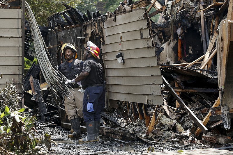 Chattanooga Fire Department fire investigators Capt. Anthony Moore, right, and Lt. Henry McElvain examine the scene of the apartment fire.