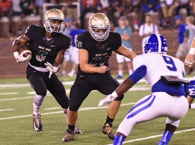 Notre Dame's Ricky Ballard (5) looks for running room beyond Nick Grannon (50) on the Irish drive to start the quarter against McCallie Friday night at Finley Stadium.