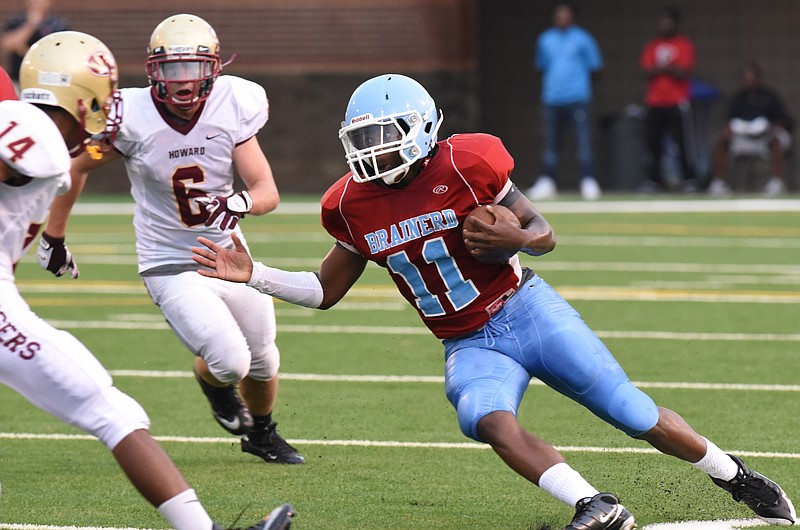 Brainerd's Robert Evans (11) cuts back to miss the tackle by Howard's Deveontae Overton (14) as Johnny Pendergrass (6) approaches in the Jamboree opener Friday at Finley Stadium.