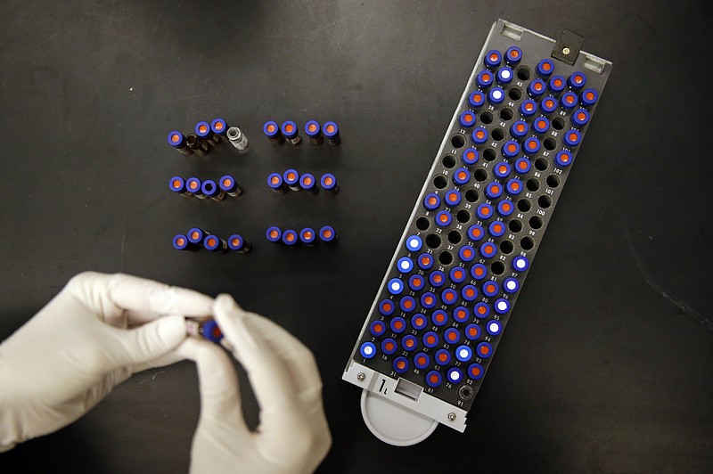 In this Aug. 10, 2015, photo, Christine Jelinek, a postdoctoral fellow at Johns Hopkins University, works alongside a tray of vials containing cerebral spinal fluid in Baltimore. Dr. Akhilesh Pandey, a researcher at Johns Hopkins University, said his research analyzes both adult and fetal tissue, and by identifying which proteins are present, he can get clues that could be used to help detect cancer in adults earlier.