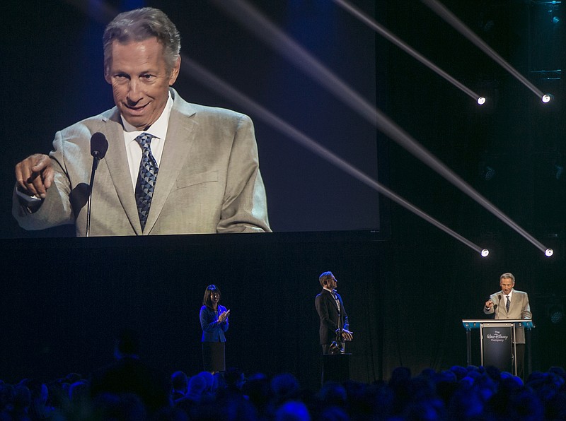 
              Carson Van Osten, right, who helped bring Disney characters to life in a variety of media, all around the world, for three decades accepts the Disney Legend Award honor from Disney CEO Bob Iger, second from left, on Friday, Aug. 14, 2015, in Anaheim, Calif. The Walt Disney Company honors those who have made significant contributions to the Disney legacy by naming them Disney Legends. (AP Photo/Damian Dovarganes)
            