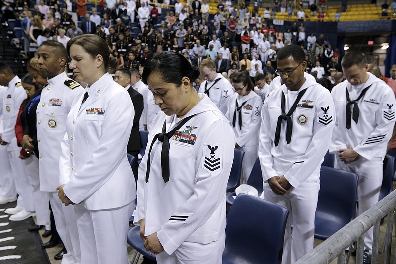 U.S. Navy sailors bow their heads during the invocation at a memorial for the five military servicemen killed in the July, 16, attacks on two military facilities held Saturday, Aug. 15, 2015, at McKenzie Arena in Chattanooga, Tenn. Vice President Joseph Biden and Secretary of Defense Ash Carter spoke along with representatives from the U.S. Navy and Marine Corps.