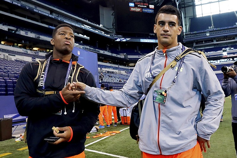 Florida State quarterback Jameis Winston, left, shakes the hand of Oregon quarterback Marcus Mariota during the NFL football scouting combine in Indianapolis this past February.