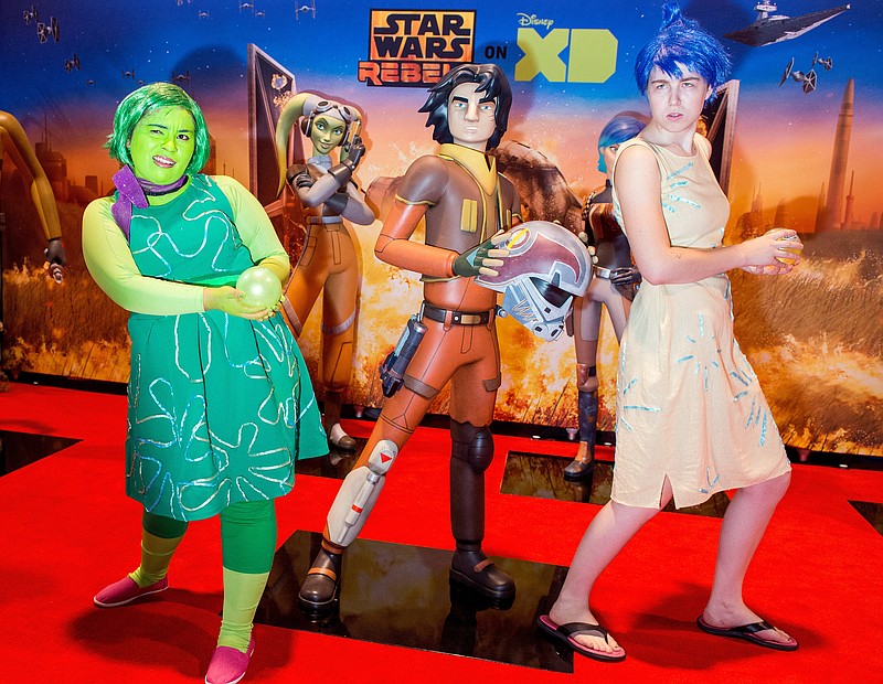 
              Lizet Guzman, 20, left, and Juliet Jans, 19, both of Anaheim, Calif., pose with Star Wars figures at the second day of D23 EXPO 2015 at the Anaheim Convention Center n Anaheim, Calif., Saturday, Aug. 15, 2015. Guzman dressed as Disgust and Jans as Joy, both from "Inside Out."  (Leonard Ortiz/The Orange County Register via AP)
            