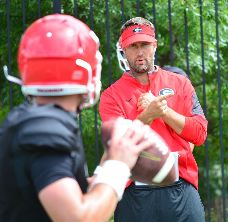 New Georgia offensive coordinator Brian Schottenheimer works with quarterbacks during Monday's practice.