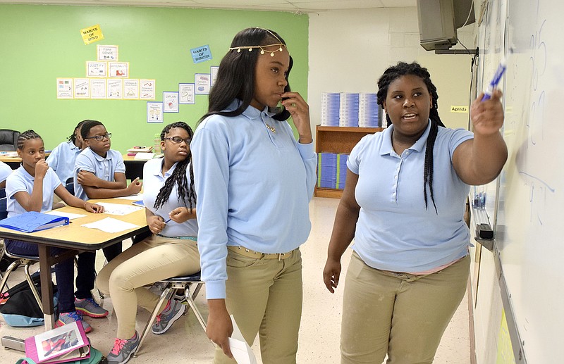 Seventh graders Cordaja Johnson (right) and Destiny Abernathy explain how they formed their math question  to the rest of Michael McKamey's math class.  Dalewood Middle School is one of several iZone schools in the Hamilton County System that is working to improve test scores.  