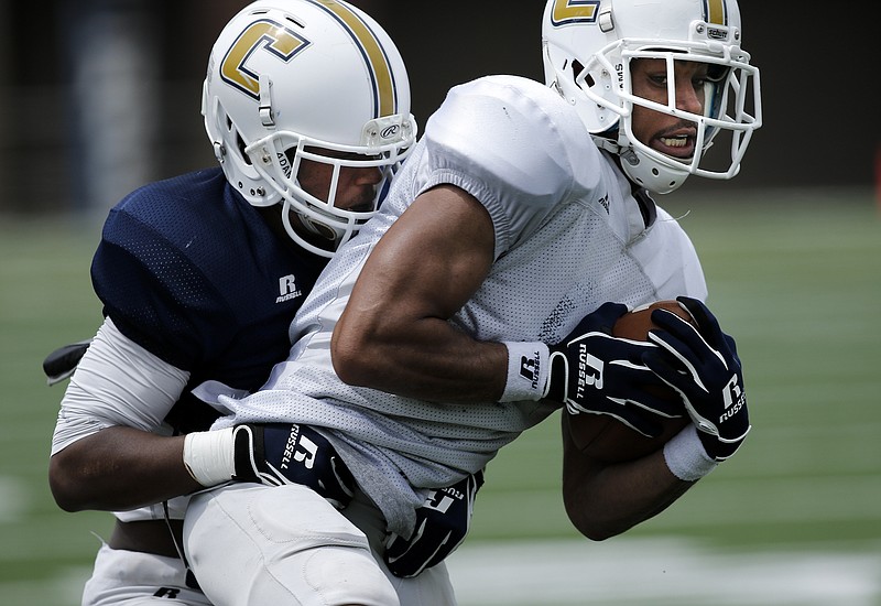 UTC defensive back Trevor Wright wraps up wide receiver C.J. Board during the UTC Mocs' spring Blue and White football game Saturday, April 18, 2015, at Finley Stadium in Chattanooga. The white team won 6-0.