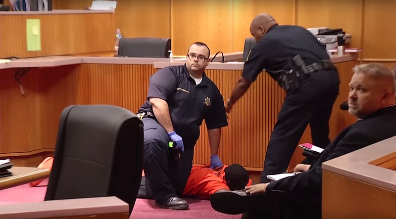 Hamilton County Court officers restrain Antwon Lee after he attacked Eric McCullough (unseen) in Judge Gary Starnes courtroom.  McCullough is accused of killing his niece who was Lee's girlfriend. Video still courtesy of Tim McCurry for Channel 3