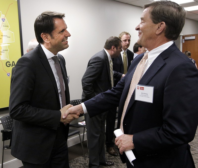 Volkswagen AG supervisory board member and Lower Saxony minister of economic affairs Olaf Lies, left, shakes hands with Bill Kilbride before a roundtable discussion on economic development at the Chattanooga Area Chamber of Commerce in this April 21, 2015, file photo.
