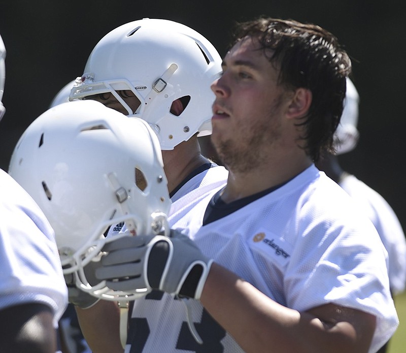 Offensive lineman Josh Cardiello puts on his helmet during the first day of practice for the University of Tennessee at Chattanooga on Aug. 3. Cardiello transferred to UTC after beginning his college career at the University of Georgia.