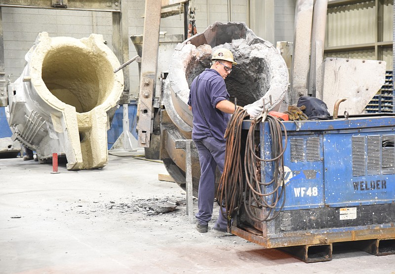 Chad Hiefurer works to remove slag from iron transport ladles Wednesday inside the Waupaca Foundry in Etowah. 