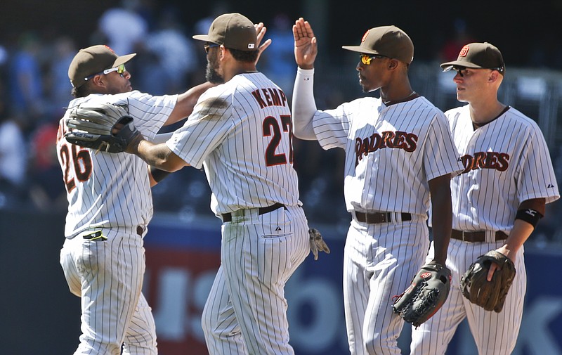 San Diego Padres' Yangervis Solarte, left, gets a "love push" out of the congratulatory line by Matt Kemp after the Padres' 3-2 victory in a baseball game Wednesday, Aug. 19, 2015, in San Diego. Solarte had three hits, including a home run and a run producing double. 