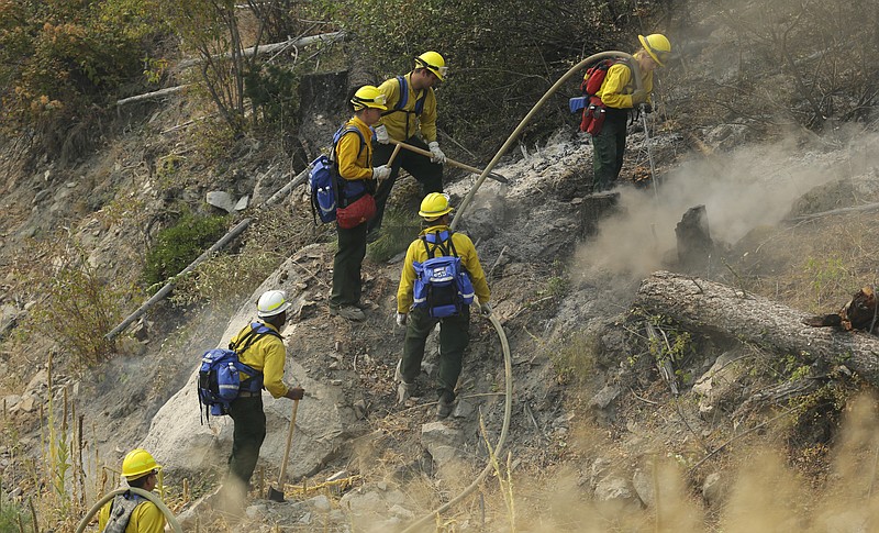 
              Firefighters and Washington National Guard soldiers work to extinguish hot spots on a hillside as they fight the First Creek Fire, Wednesday, Aug. 19, 2015, near Chelan, Wash. Firefighters braced Wednesday for high winds and heat that could fuel wildfires that have evacuated towns and destroyed houses in Washington state. (AP Photo/Ted S. Warren)
            