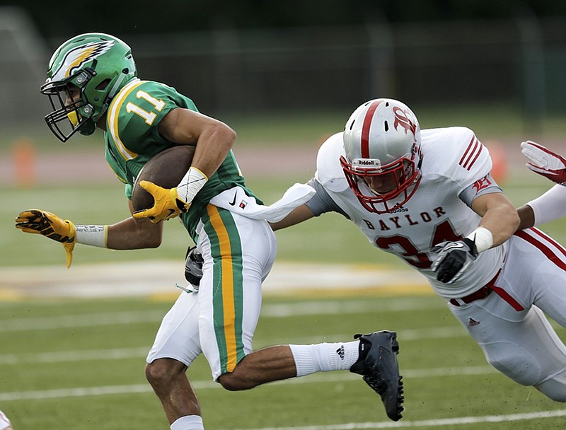 Rhea County's Noel Patterson slips past Baylor's Charlie Glascock during the season opener for both teams Thursday night at Rhea County High School. Few Chattanooga-area schools have been willing to play Baylor or McCallie since the TSSAA's 1997 public-private split.