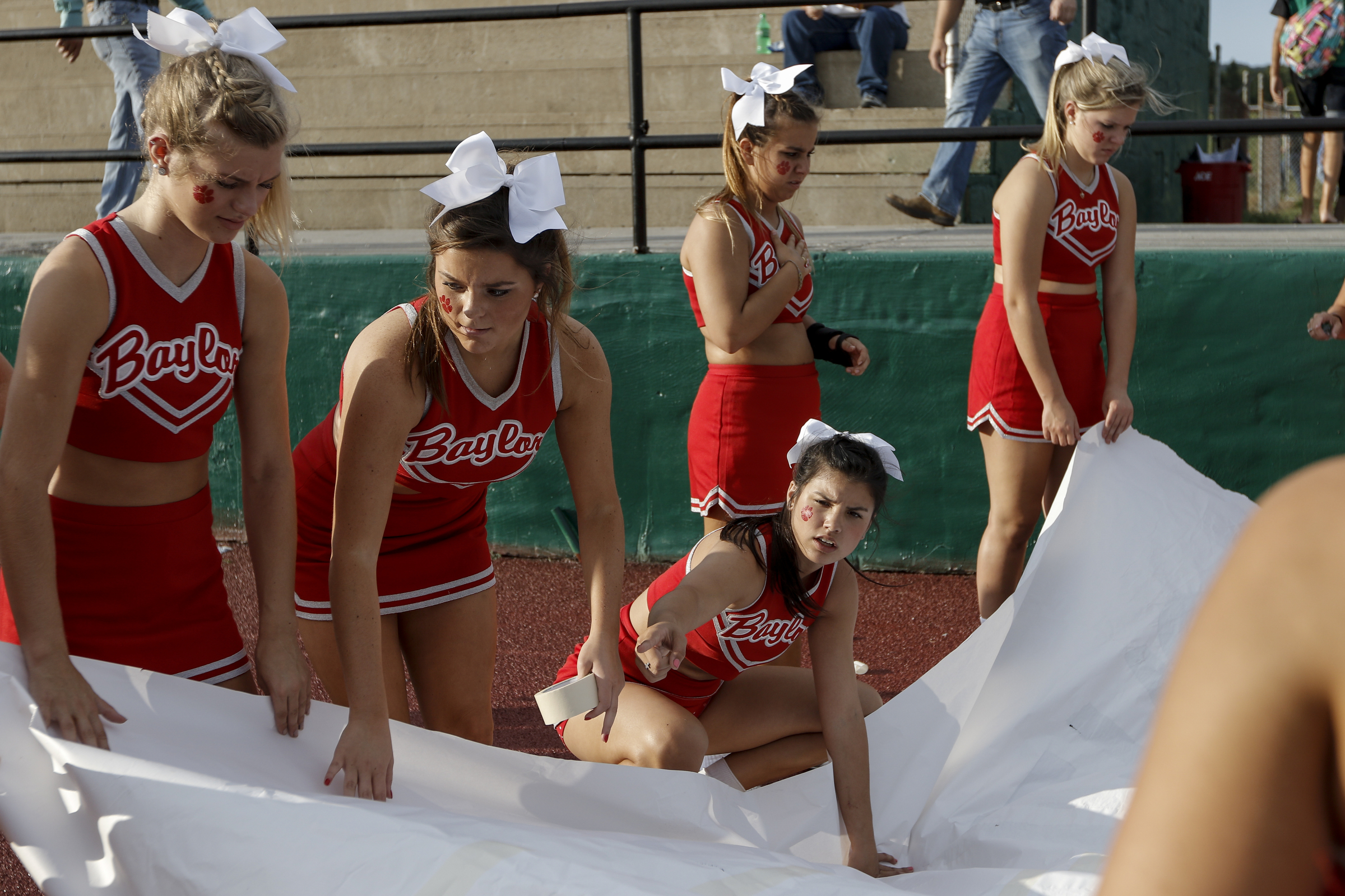 Baylor cheerleaders prep their banner before their prep football game against Rhea County at Rhea County High School on Thursday, Aug. 20, 2015, in Evensville, Tenn.