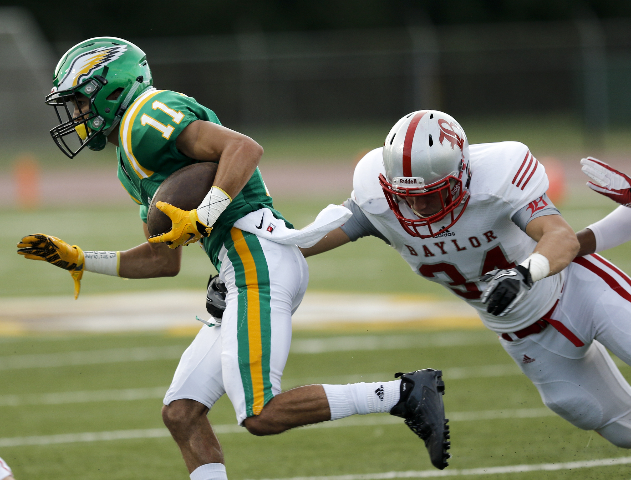 Rhea County's Noel Patterson (11) rushes around Baylor's Charlie Glascock during their prep football game at Rhea County High School on Thursday, Aug. 20, 2015, in Evensville, Tenn.
