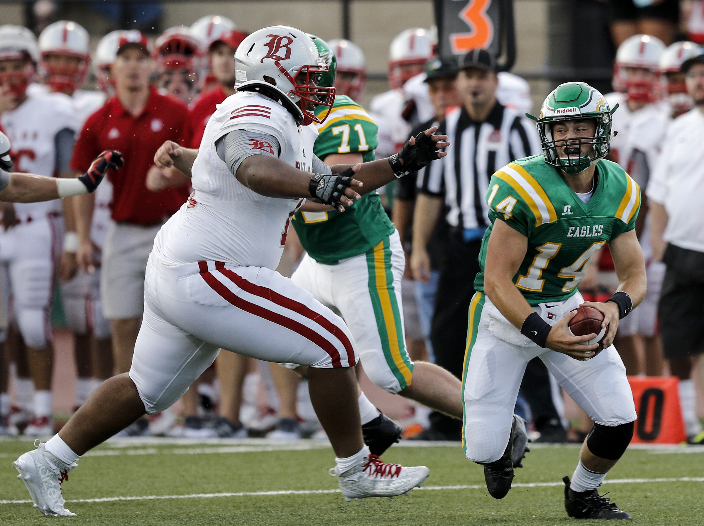 Rhea County quarterback Daniel Dotson, right, tries to get away from Baylor lineman Isaiah Strawter during their prep football game at Rhea County High School on Thursday, Aug. 20, 2015, in Evensville, Tenn.