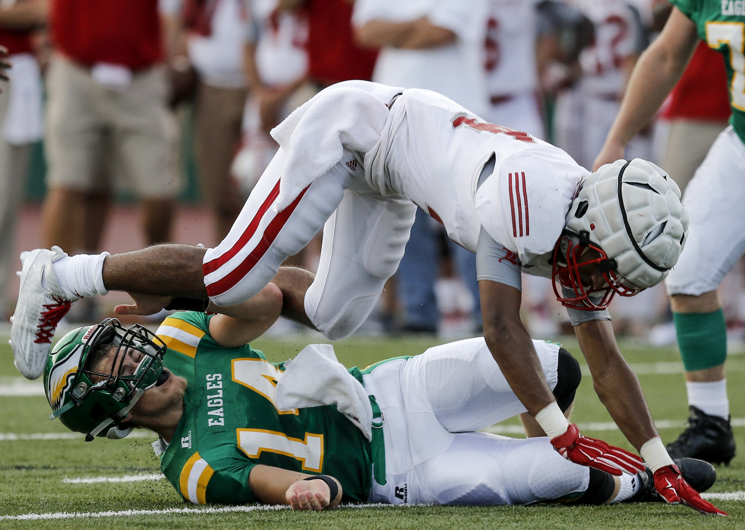 Rhea County quarterback Daniel Dotson's helmet comes loose as he is hit by Baylor's Daniel Monroe during their prep football game at Rhea County High School on Thursday, Aug. 20, 2015, in Evensville, Tenn.