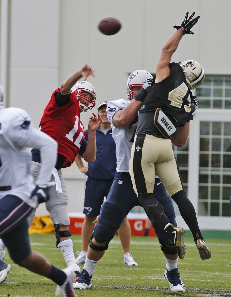 
              New England Patriots quarterback Tom Brady (12) tosses a pass over New Orleans Saints safety Vinnie Sunseri, right, during a joint practice between the Patriots and New Orleans Saints at the Saint's NFL football training camp in White Sulphur Springs, W.Va., Thursday, Aug. 20, 2015.  (AP Photo/Steve Helber)
            