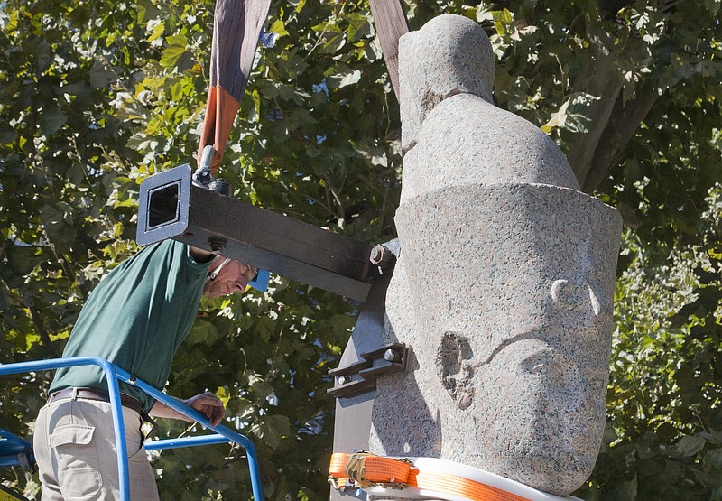 
              A worker sets up a statue of an unnamed king dating from the Ptolemy era, made of pink granite and measuring 5 meters (16 feet) and weighing 5.5 tons in Paris, Friday Aug 21, 2015.  The Institut du Monde Arabe (Arabic World Institute) opens on Sept. 8 2015 with its exhibition “Osiris, Egypt’s Sunken Mysteries”, an exhibition revealing one of the founding myths of ancient Egypt. (AP Photo/Jacques Brinon)
            