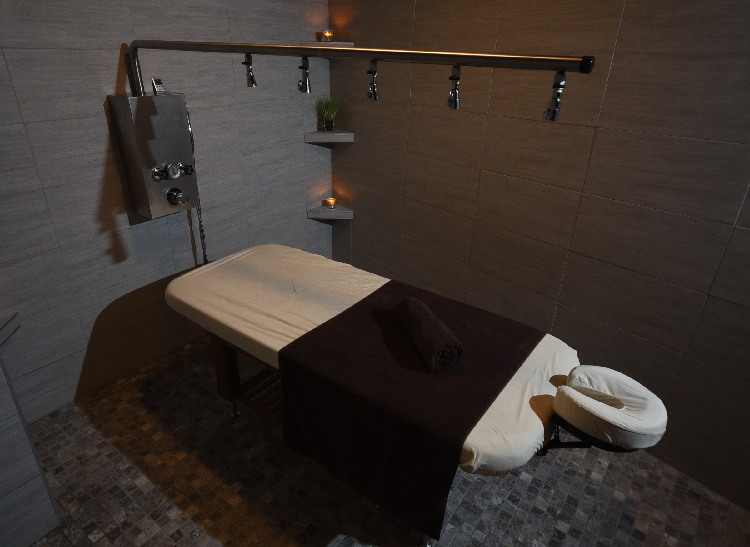 A total body wash from multiple shower heads is administered during the massage.