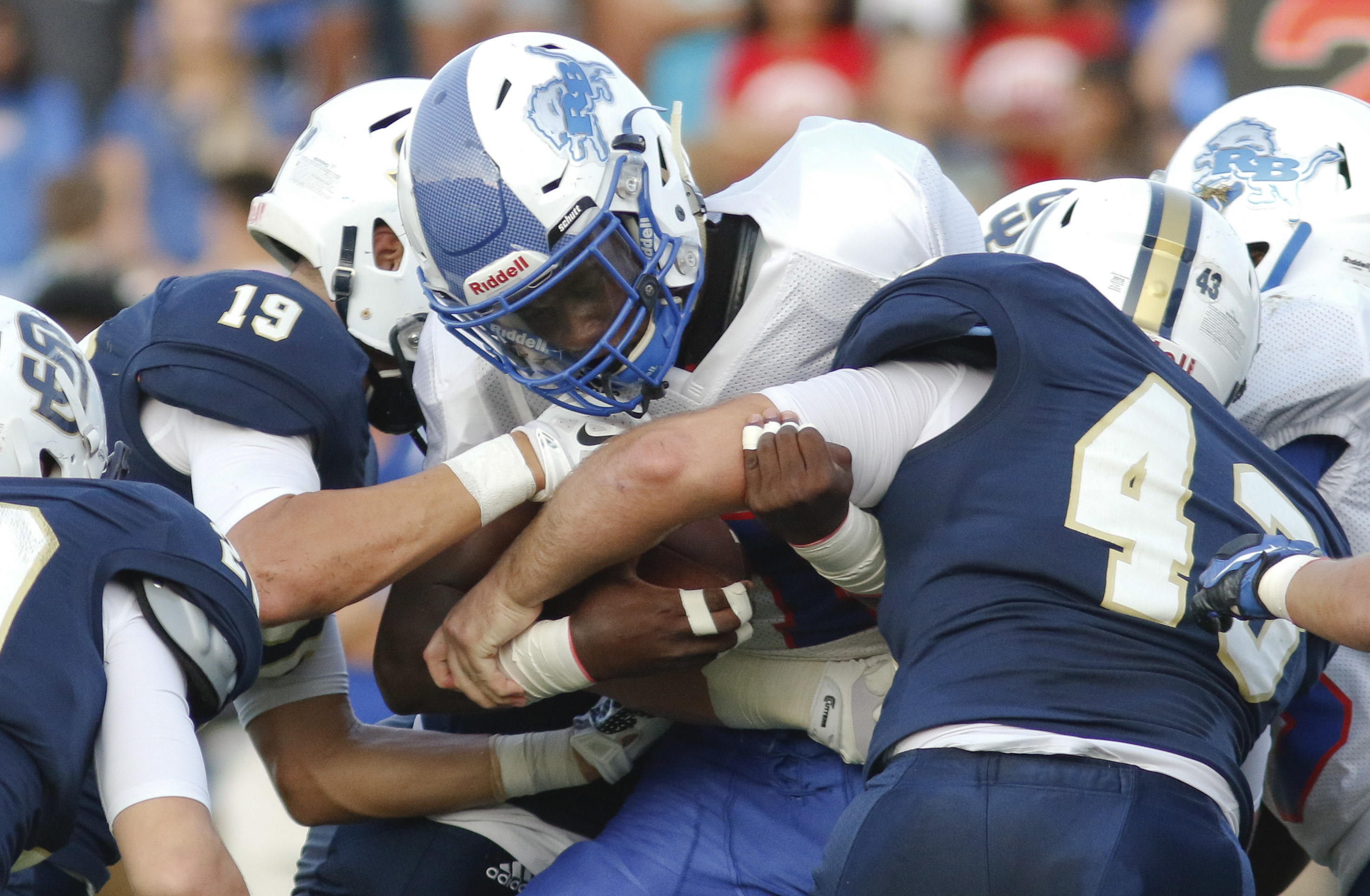 Red Bank High School's Demarcus Rivers (1) gets taken down by Soddy-Daisy's Jacob Jordan (19) and Harrison Huskey (43) during the first half of play at the Trojan's Robert Talaska field on August 21, 2015.