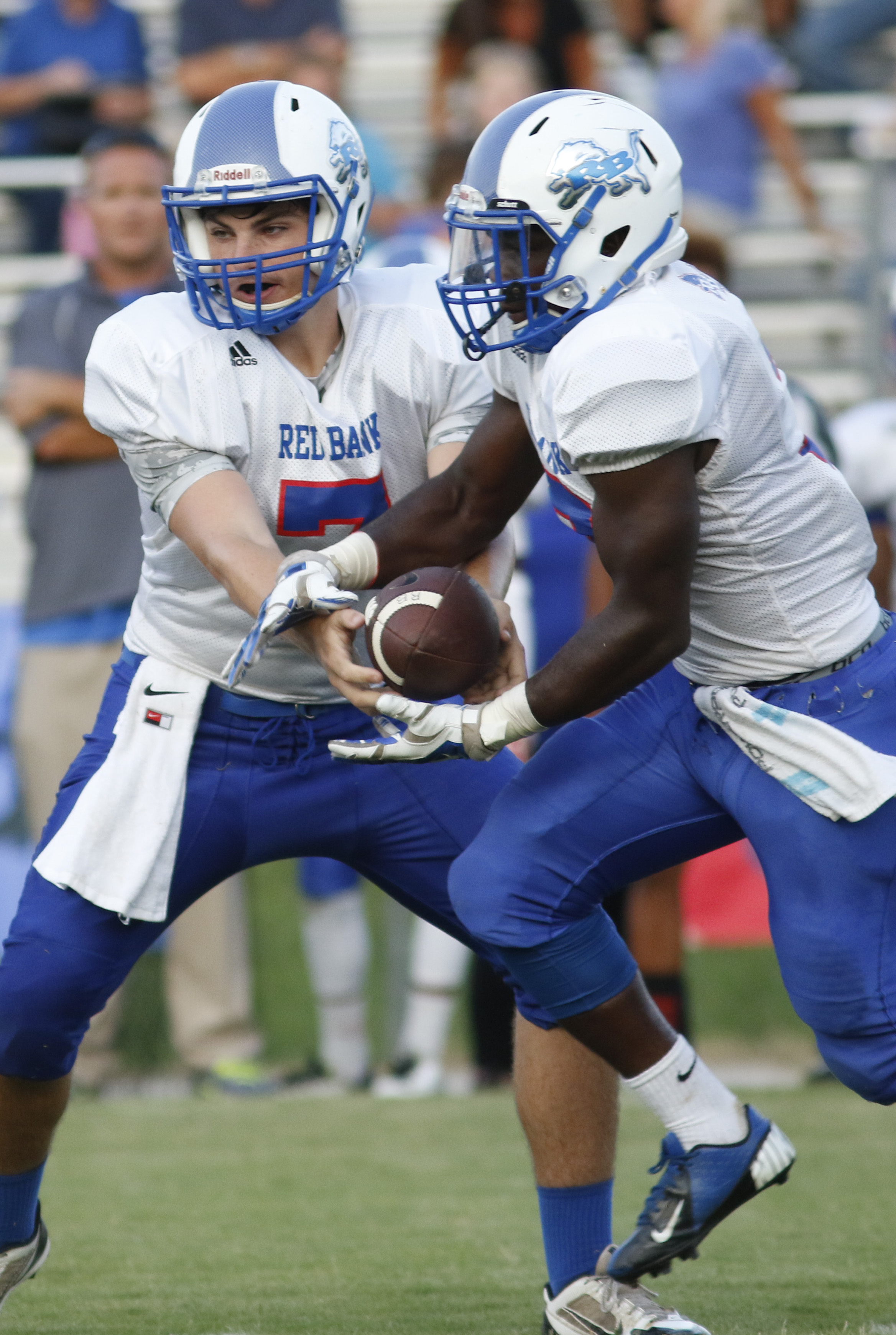 Red Bank High School quarterback Caleb Tate (7) hands off to teammate Destein Henderson (3) while playing Soddy-Daisy during the first half of play at the Trojan's Robert Talaska field on August 21, 2015.