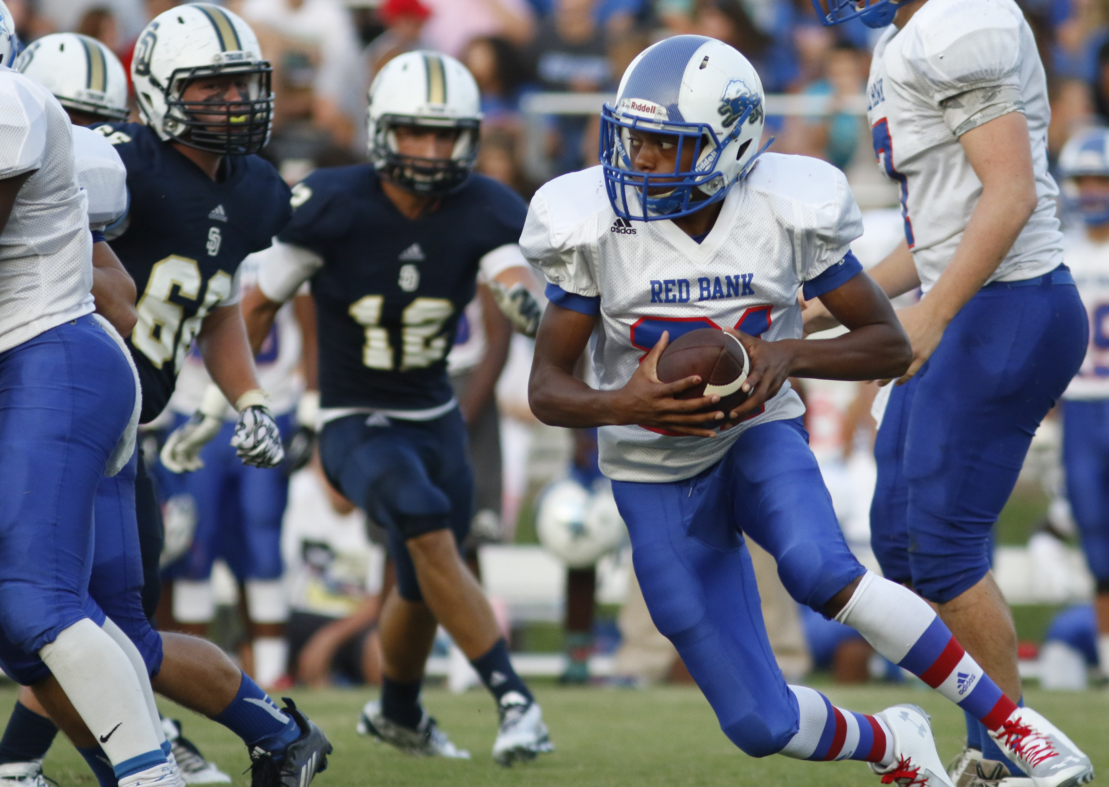 Red Bank High School's Calvin Jackson (21) looks for a hole in the Soddy-Daisy defense during the first half of play at the Trojan's Robert Talaska field on August 21, 2015.