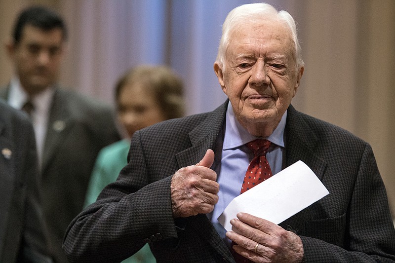 
              Former President Jimmy Carter walks to a news conference followed by his wife, Rosalynn Carter, center, at The Carter Center in Atlanta on Thursday, Aug. 20, 2015. Carter announced that his cancer is on four small spots on his brain and he will immediately begin radiation treatment, saying he is "at ease with whatever comes." (AP Photo/Ron Harris)
            