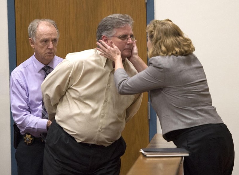 John Brichetto, center, is taken into custody as his wife, Lisa Horn Brichetto leans to kiss him after he was sentenced to 10 years prison in Morgan County Criminal Court on Wednesday. The Brichettos were principals in Northington Energy LLC, and were indicted by a Morgan County grand jury in May 2011 over allegations they stole $142,250 of a state loan the company received for the construction of a biodiesel fuel facility just outside Wartburg, Tenn.