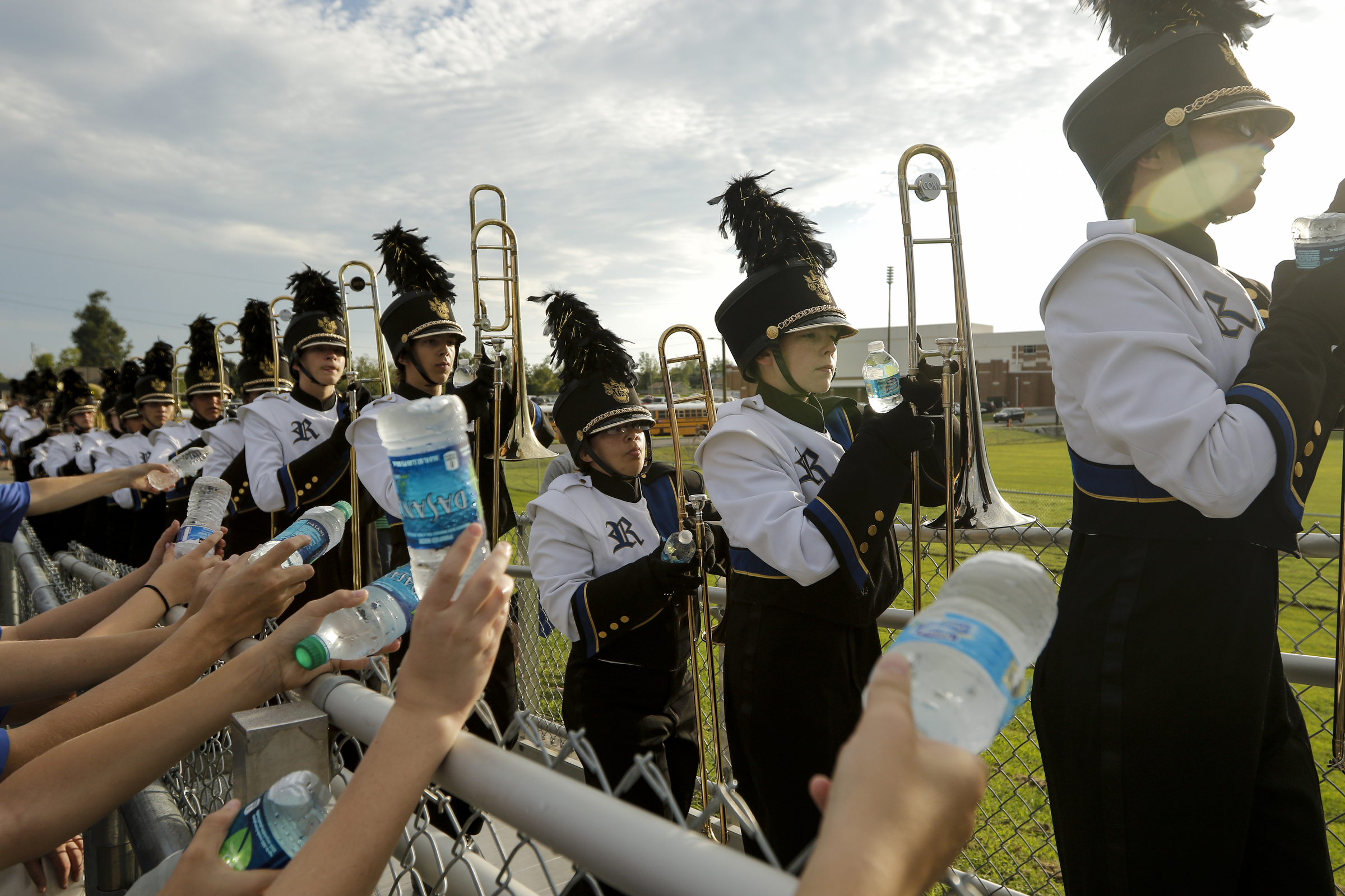 Volunteers hand water to members of the Ringgold band as they enter the stands before their team's prep football game against Northwest Whitfield at Ringgold High School on Saturday, Aug. 22, 2015, in Ringgold, Ga.