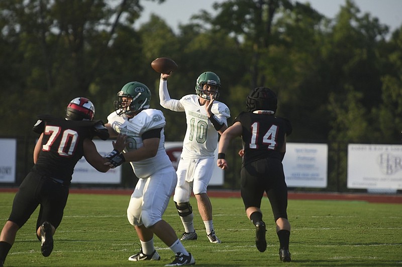 East Hamilton quarterback Nicholas Woods passes as Signal Mountain's Jack Chandler closes in during Friday's season opener at Signal Mountain.
