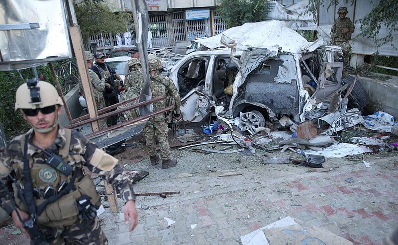Afghan security forces and British soldiers inspect the site of a suicide attack in the heart of Kabul, Afghanistan, on Aug. 22, 2015. 