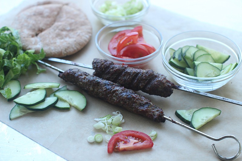 Traditional shish kebab is ground meat, woven together with onions, parsley and a native spice mix, molded onto a metal skewer like a delicate sausage, then cooked over smoldering coals. (AP Photo/Matthew Mead)