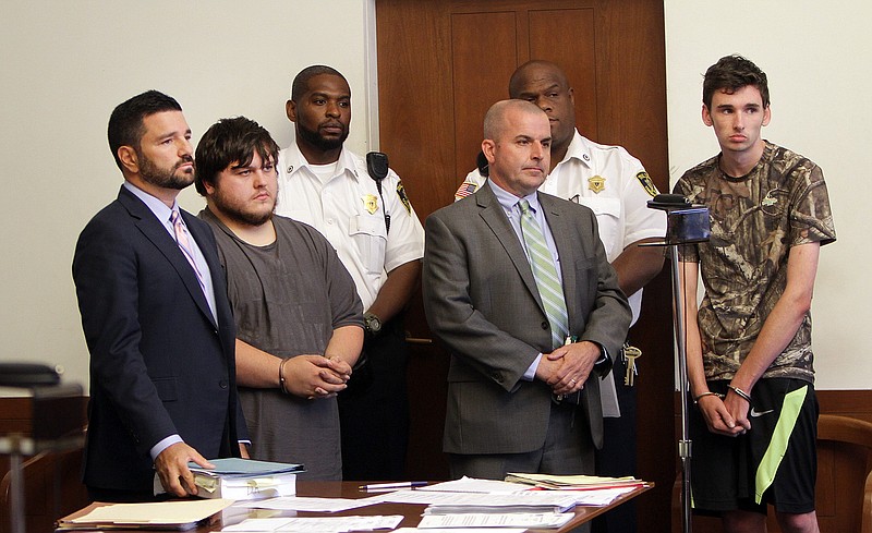 
              James Stumbo, second from left, and Kevin Norton, right, both of Iowa, stand in court during their arraignment at Boston Municipal Court in Boston, Monday, Aug. 24, 2015 with their lawyers Steven Goldwyn, left, and John O'Neill, Jr., second from right.  Stumbo and Norton were arrested and charged with unlawful possession of a firearm, unlawful possession of ammunition and other firearms charges after allegedly threatening the Pokémon World Championships at Hynes Convention Center in Boston. (Chitose Suzuki/Boston Herald via AP, Pool)
            