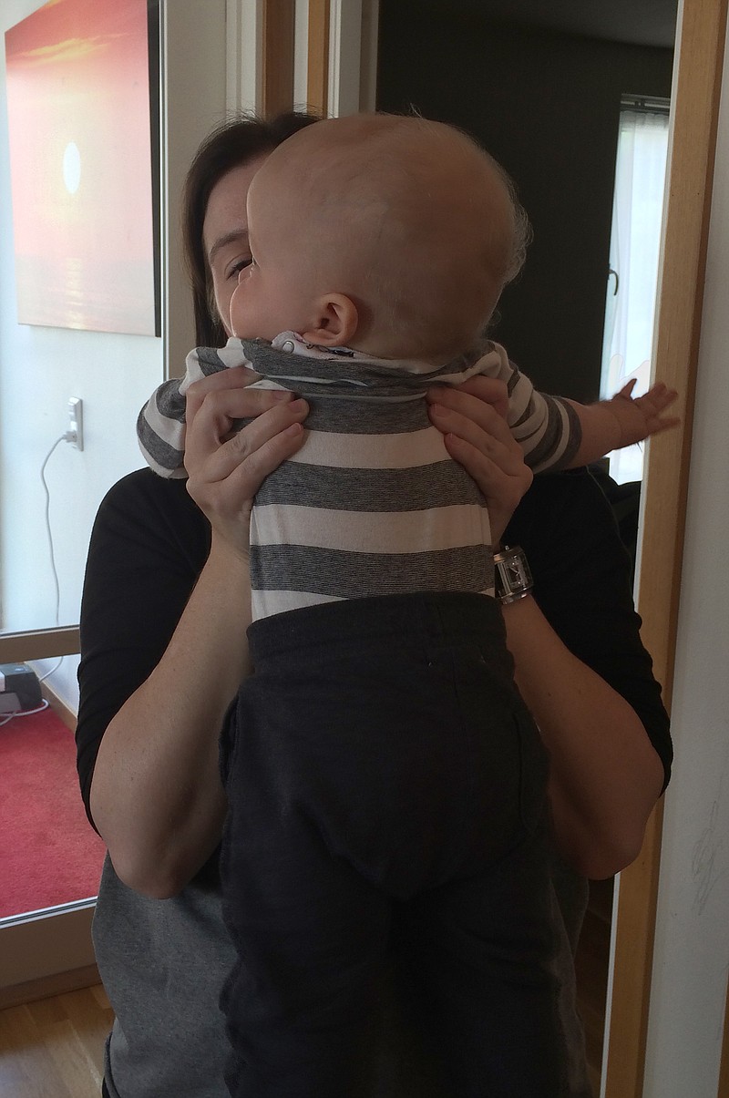 
              A young Swedish mother holds  her child in an apartment in  Gothenburg Sweden Sunday Aug. 16, 2015. For this family in Sweden, a pioneering procedure has led to a baby being born from the same womb that nurtured his mother, uniting three generations.  The new mother, who lost her own uterus to cancer in her 20s, said it was “unimaginable” that she now had her own child, thanks to her mother’s donated womb. (AP Photo/Maria Cheng)
            
