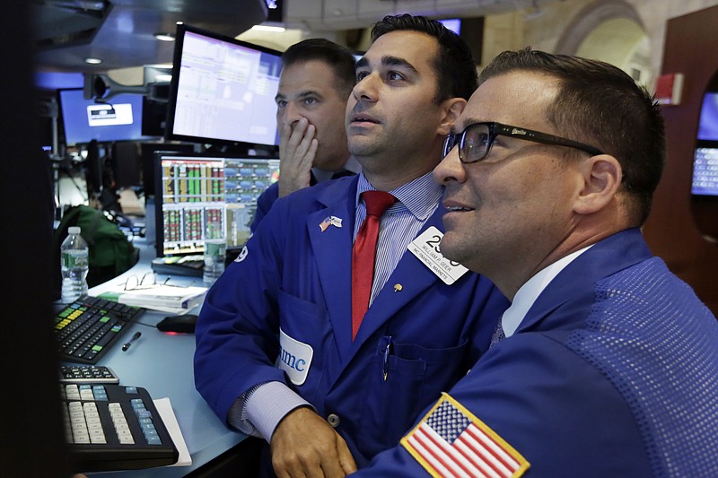 A trio of specialists look at screen at a post on the floor of the New York Stock Exchange, Tuesday, Aug. 25, 2015. U.S. stocks closed lower Tuesday after falling sharply in the final hour of trading. (AP Photo/Richard Drew)
