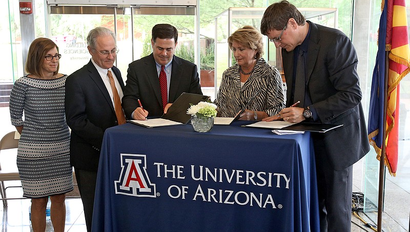 
              Gov. Doug Ducey, third left, signs an agreement with University of Arizona President Ann Weaver, second right, and Brian McClendon, the vice president for Uber which will allow them to the test and do research on driverless technology in the Tucson area, Tuesday, Aug. 25, 2015, in Tucson, Ariz. Rep Martha McSally, far left, and Mayor Jonathan Rothschild witnessed the signing. Ducey made the announcement at the University of Arizona Optical Sciences which will assist n the mapping and safety technology.  (A.E. Araiza/Arizona Daily Star via AP)  ALL LOCAL TELEVISION OUT; PAC-12 OUT; MANDATORY CREDIT; GREEN VALLEY NEWS OUT
            