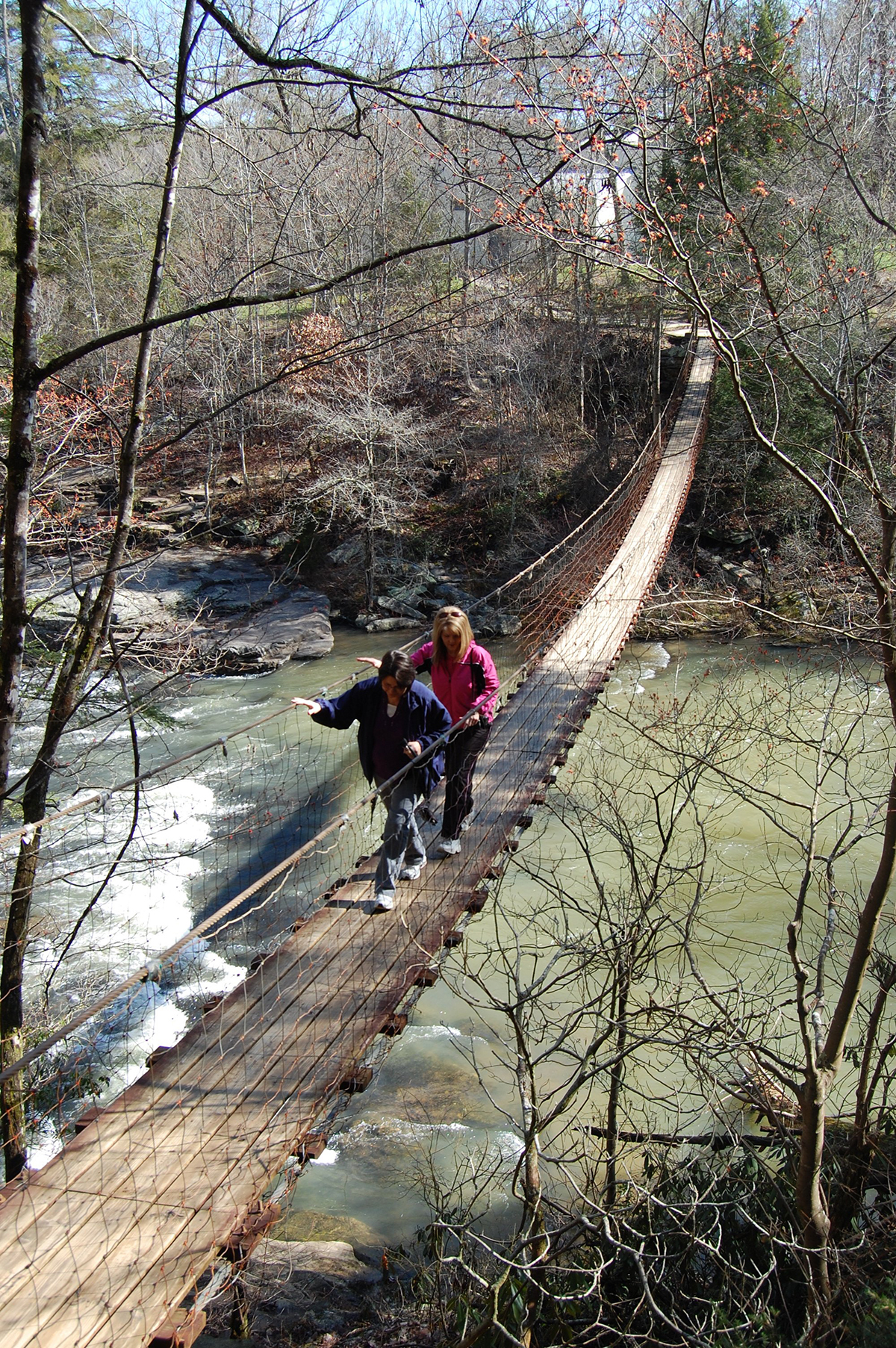 Staff Photo by Ben Benton/Chattanooga Times Free Press - Mar 19, 2013 - Fall Creek Falls State Park visitors Rhonda Bigler, foreground, and Deborah Nash cross a swinging bridge for a view of Cane Creek on Tuesday. State parks officials are surveying Fall Creek Falls guests who stay at the resort park's inn, cabins and campsites about ideas for updates and improvements.
