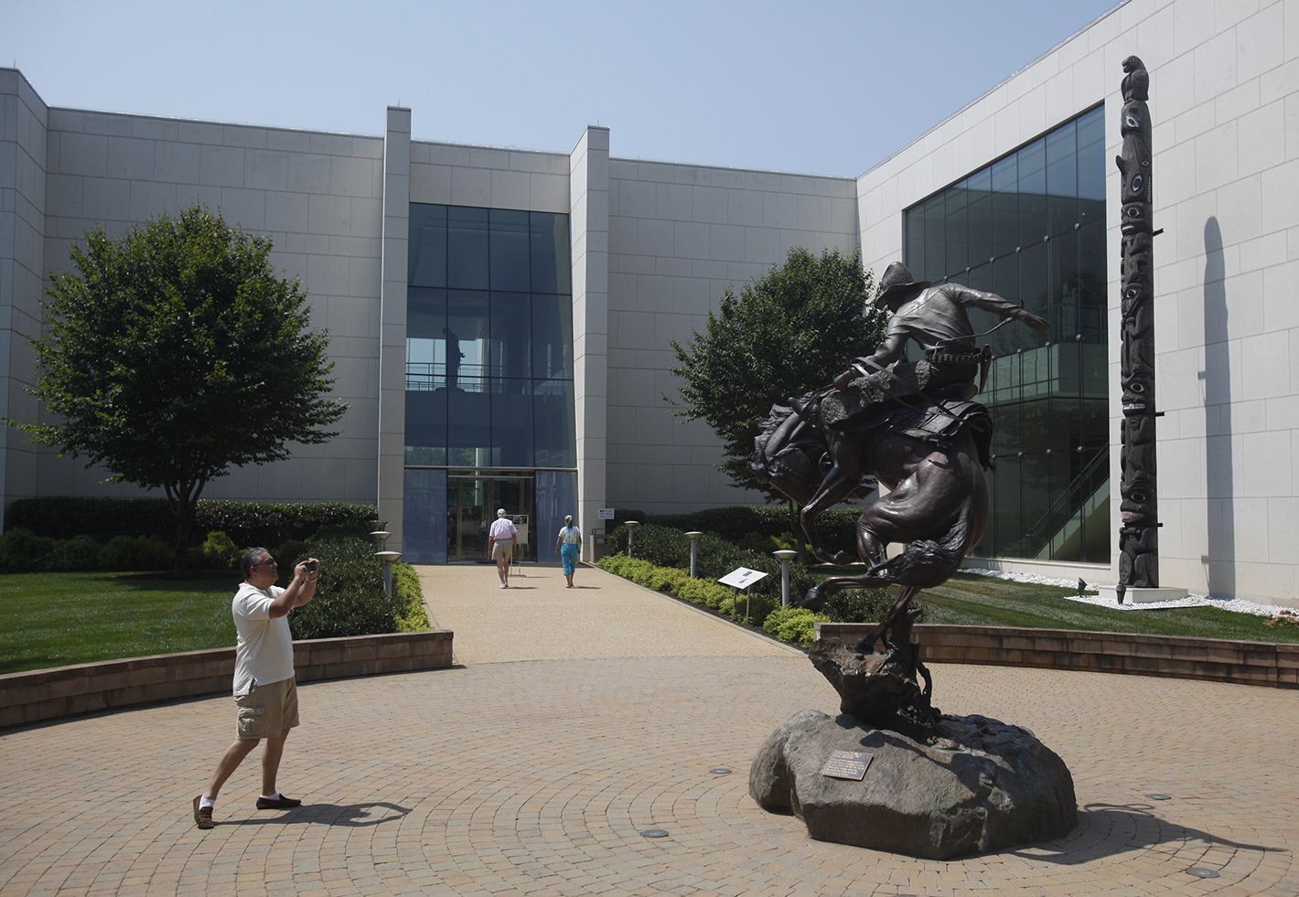 Daniel Canas {CQ}, who was visiting from Chile, takes a picture of a work outside the Booth Western Art Museum in Cartersville, Ga., on Saturday.